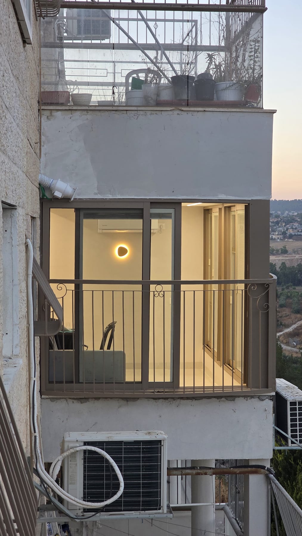 חזית הסלון מבחוץ, חלונות מוארים בשעת ערב